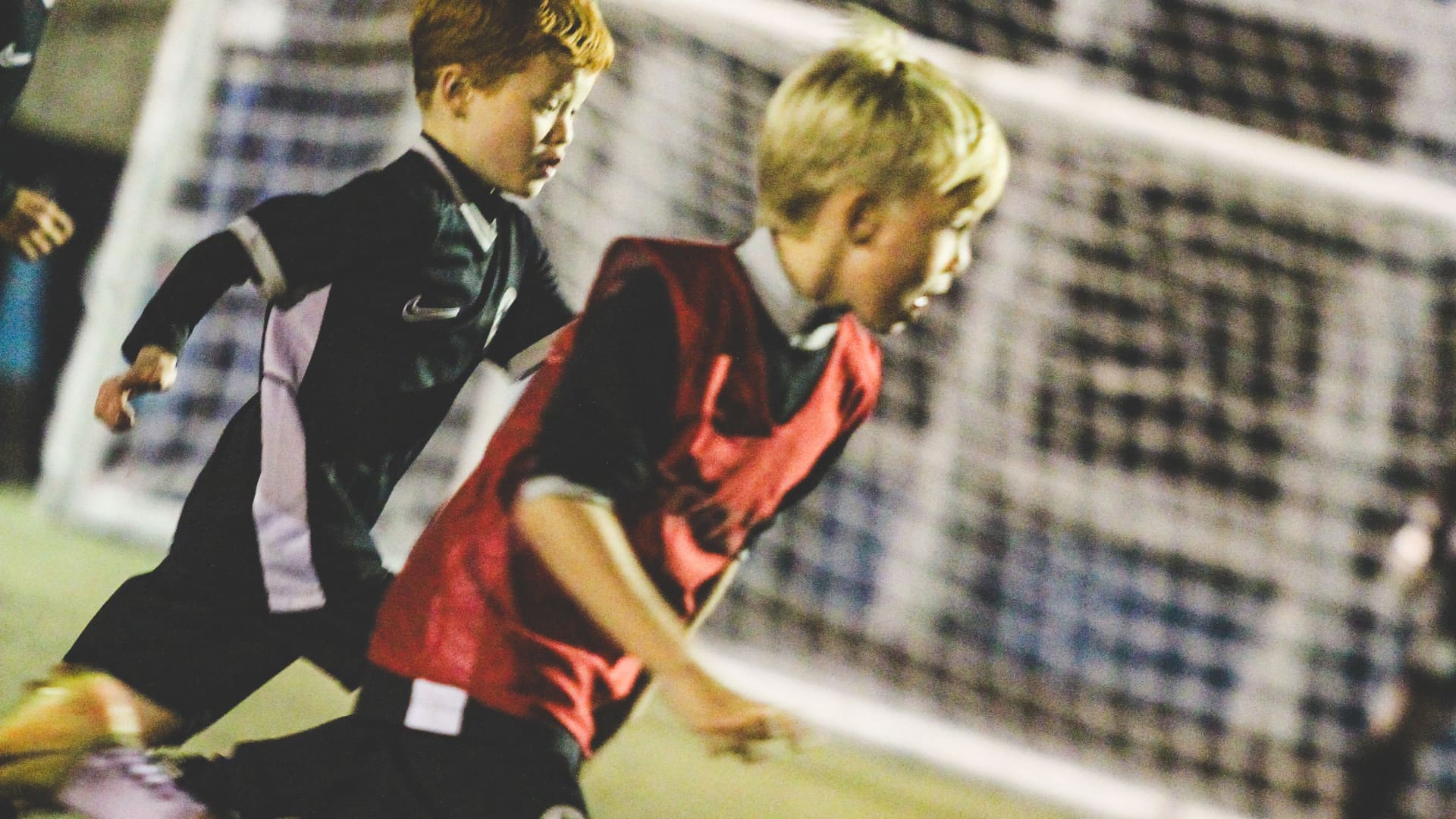 Young Fundamental FC players competing during a floodlit session