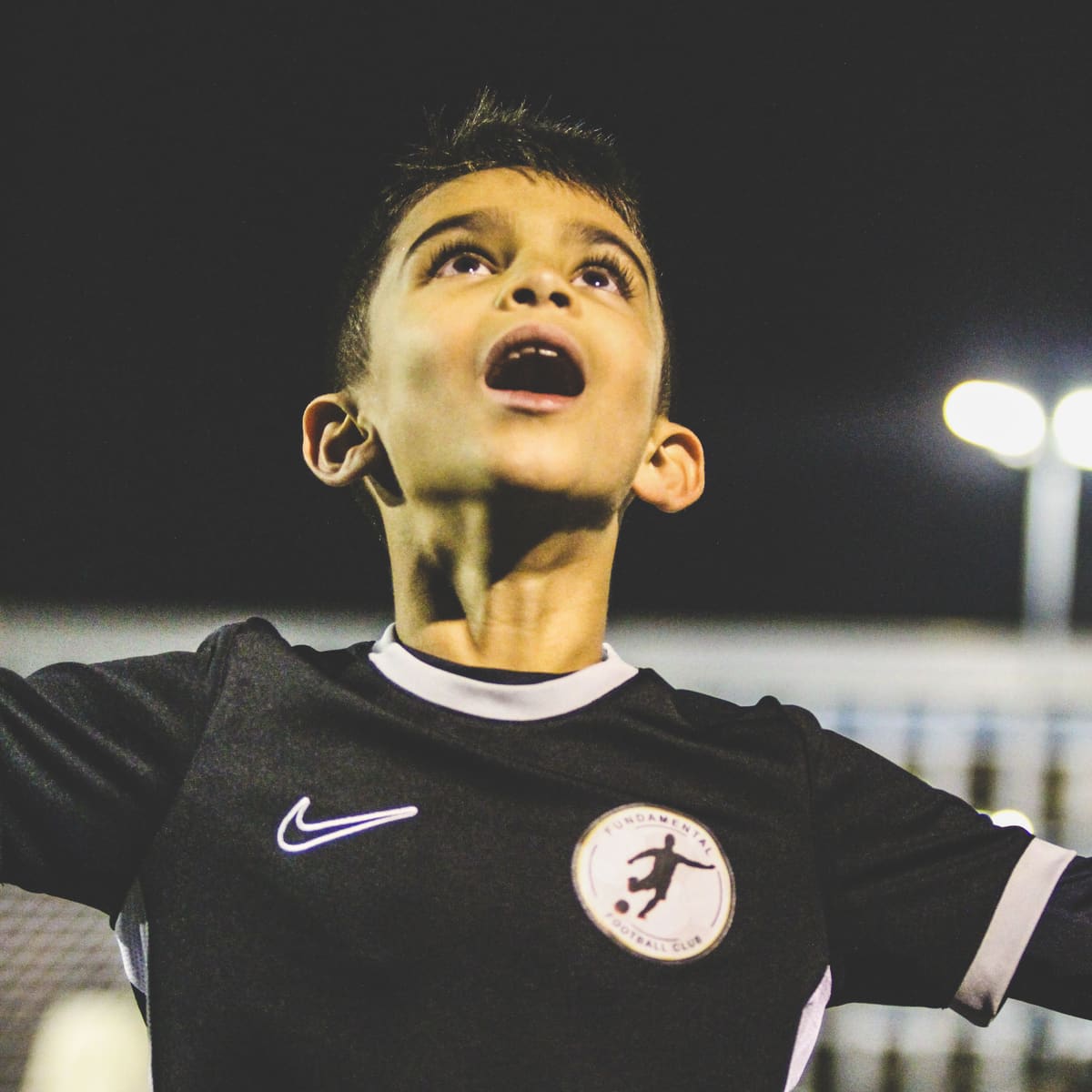 A young player looking up as the ball comes down